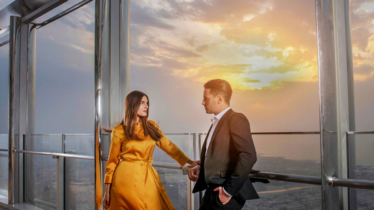 Couple enjoying sunset view from Burj Khalifa's At the Top Sky Lounge, Level 152.