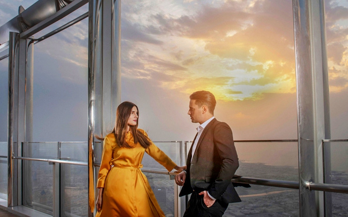 Couple enjoying sunset view from Burj Khalifa's At the Top Sky Lounge, Level 152.