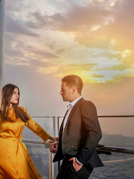 Couple enjoying sunset view from Burj Khalifa's At the Top Sky Lounge, Level 152.