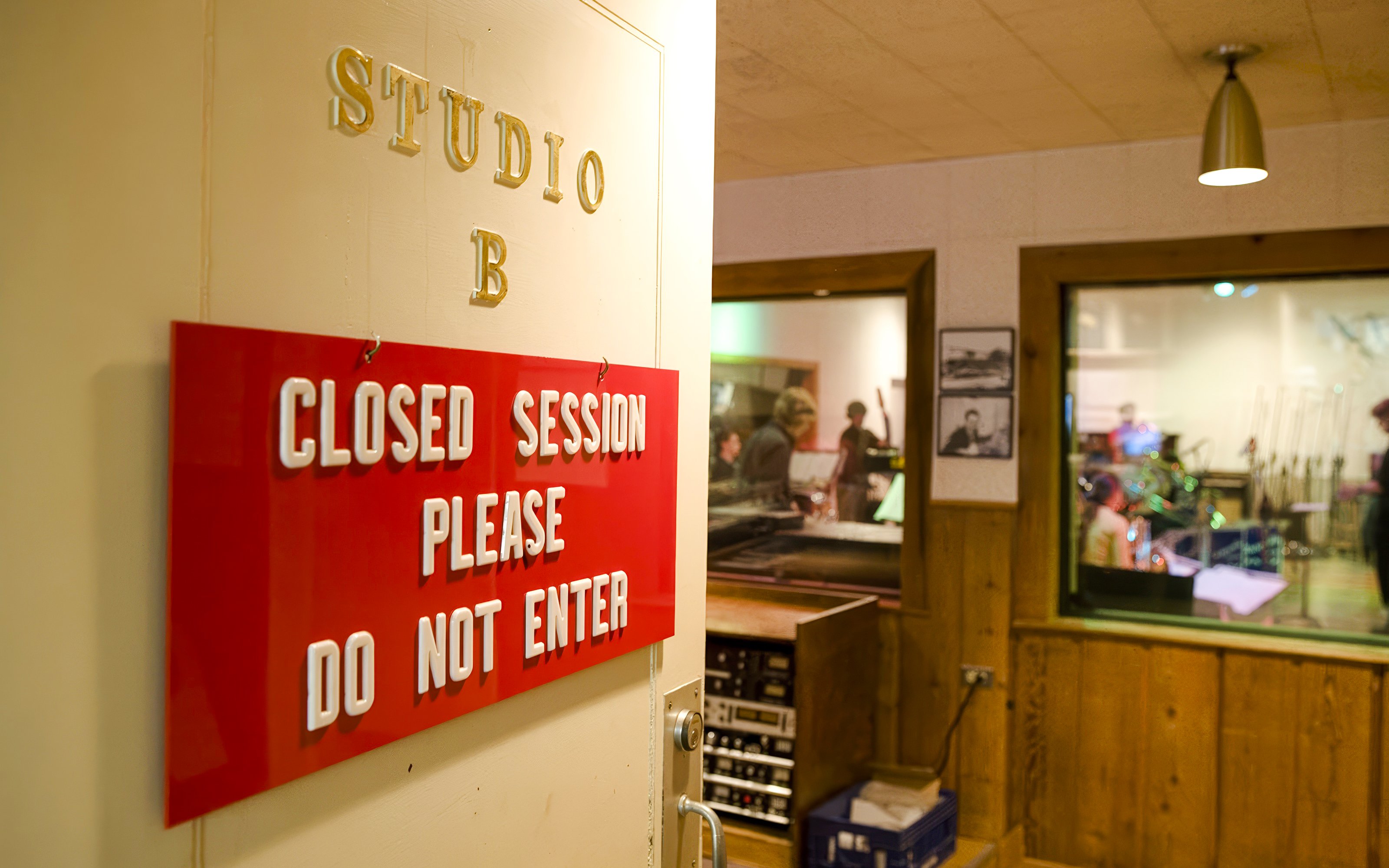 Closed session sign at Historic RCA Studio B with musicians inside recording room.