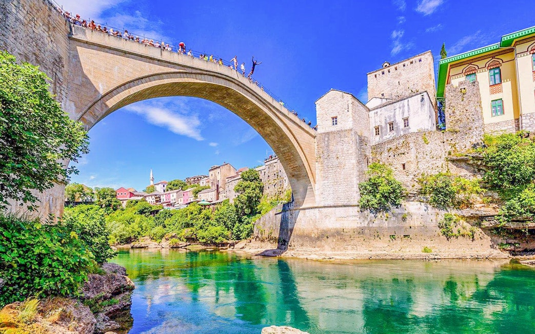 Mostar Bridge view with tourists on a private tour, Bosnia and Herzegovina.