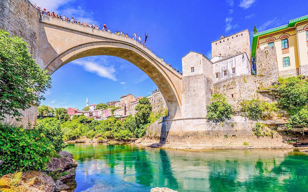 Mostar Bridge view with tourists on a private tour, Bosnia and Herzegovina.
