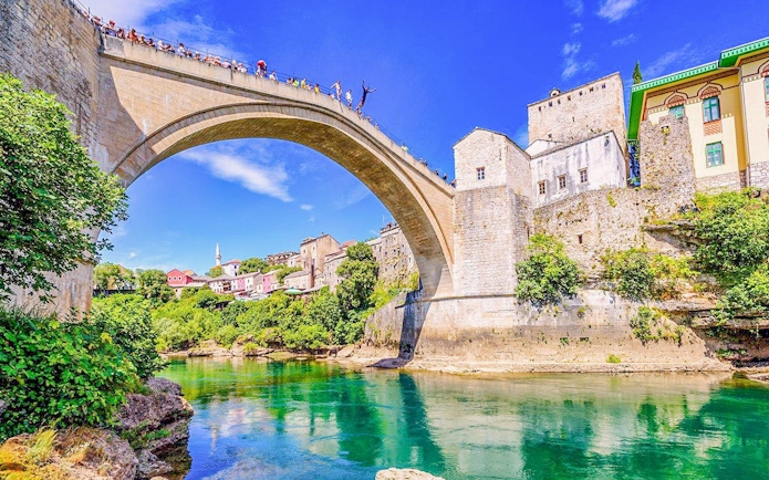 Mostar Bridge view with tourists on a private tour, Bosnia and Herzegovina.