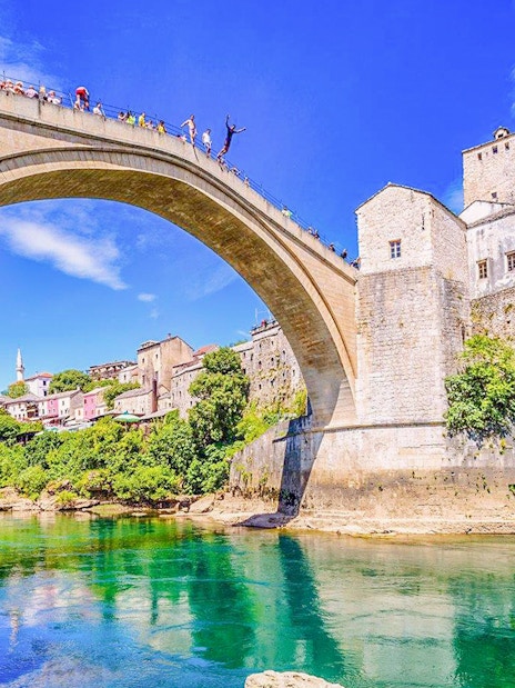 Mostar Bridge view with tourists on a private tour, Bosnia and Herzegovina.