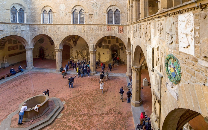 Visitors exploring the historic courtyard of Museo del Bargello in Florence.