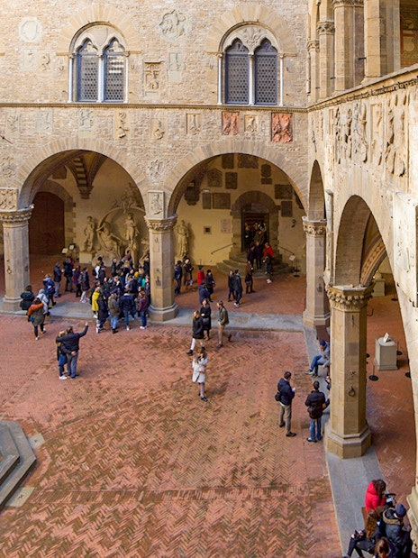 Visitors exploring the historic courtyard of Museo del Bargello in Florence.