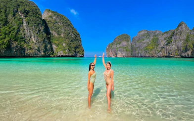 Women enjoying the clear waters at Maya Beach, Krabi, with limestone cliffs in the background.