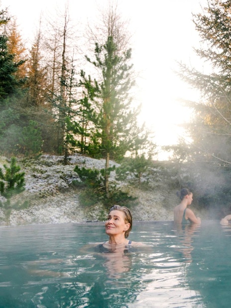 Guests enjoying a warm soak in the forest pool at Laugarás Lagoon.