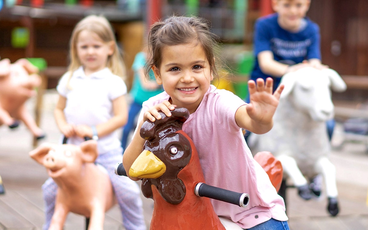 Children riding animal-themed play equipment at Ravensburger Spieleland.