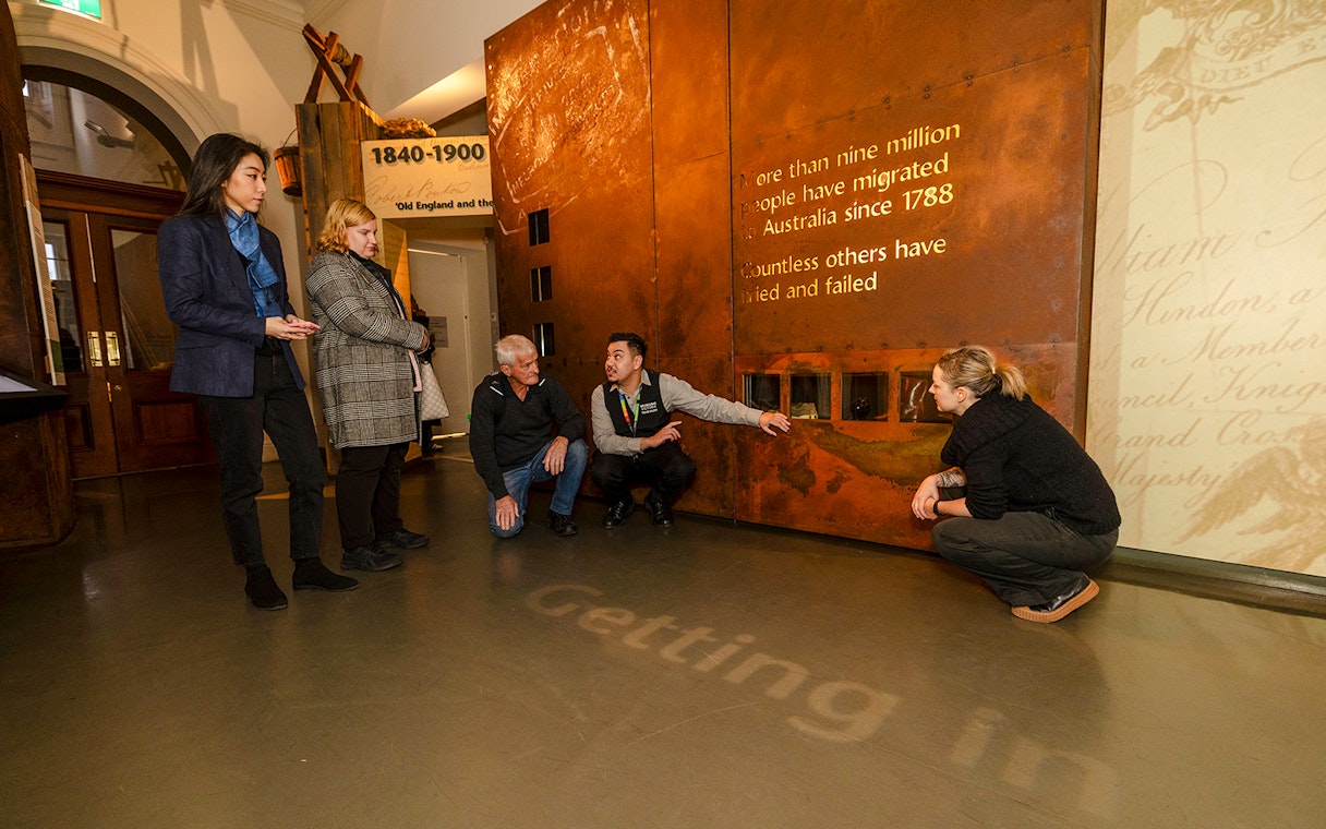 Visitors on a guided tour at the Immigration Museum, viewing historical migration exhibits.