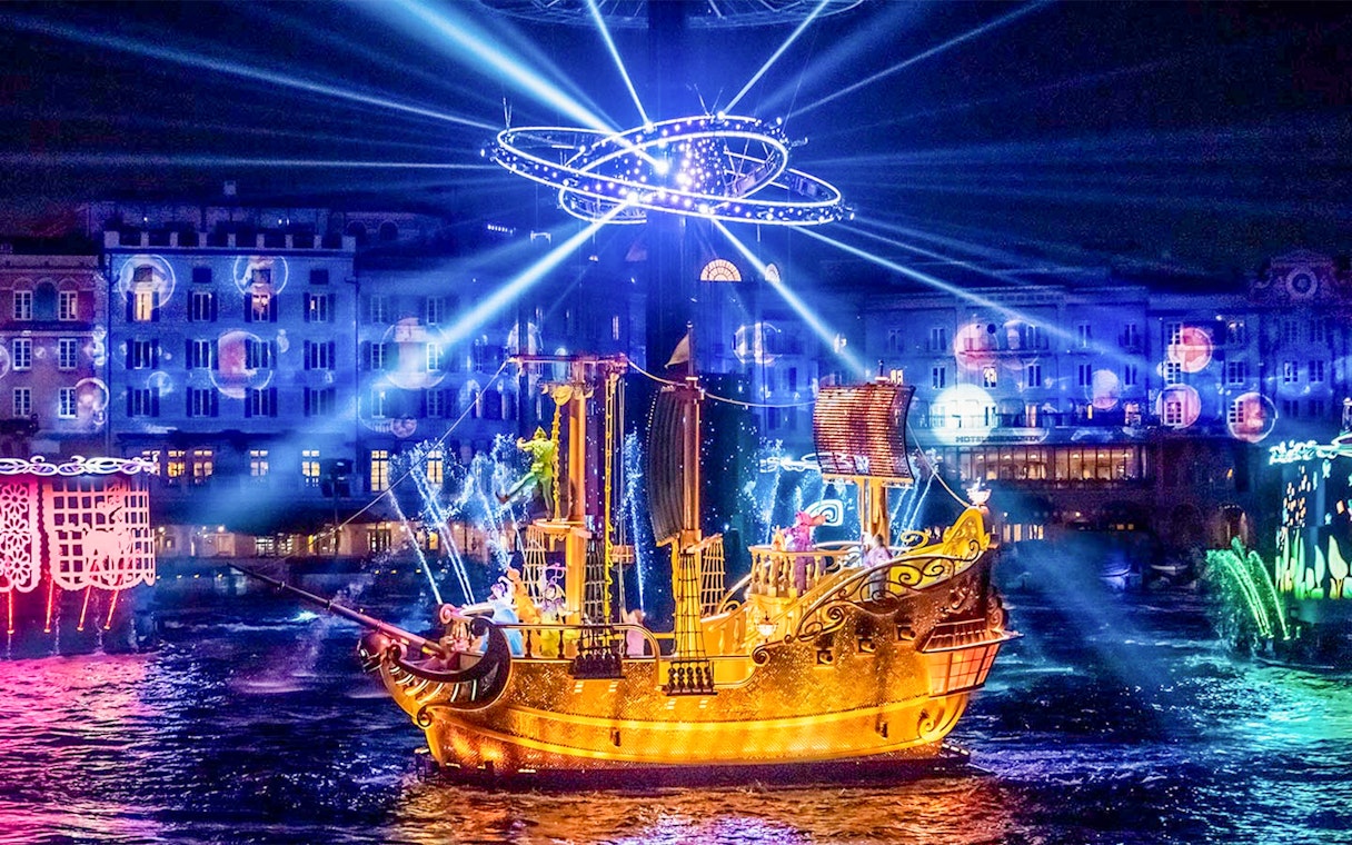 Golden ship illuminated at night during a show at Tokyo DisneySea.