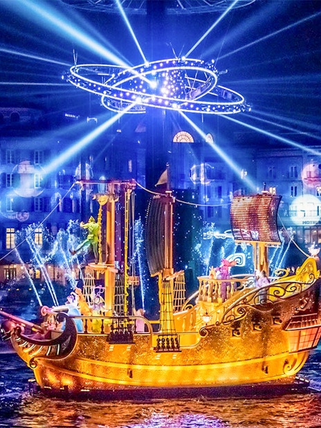 Golden ship illuminated at night during a show at Tokyo DisneySea.
