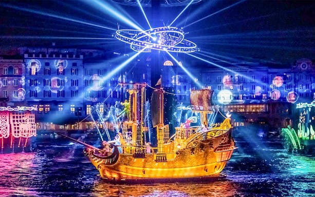 Golden ship illuminated at night during a show at Tokyo DisneySea.