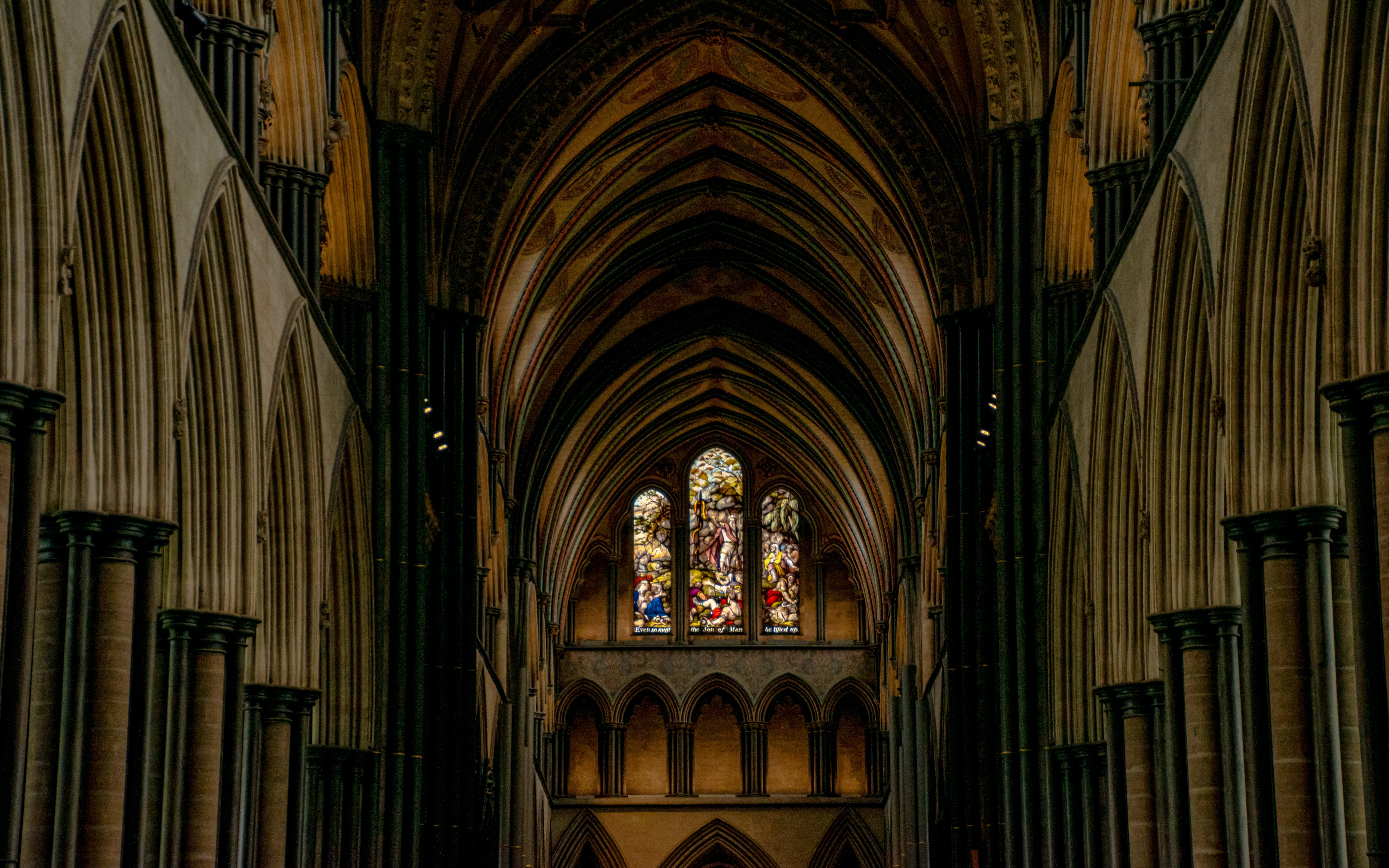 Stained glass windows and vaulted arches inside Salisbury Cathedral.