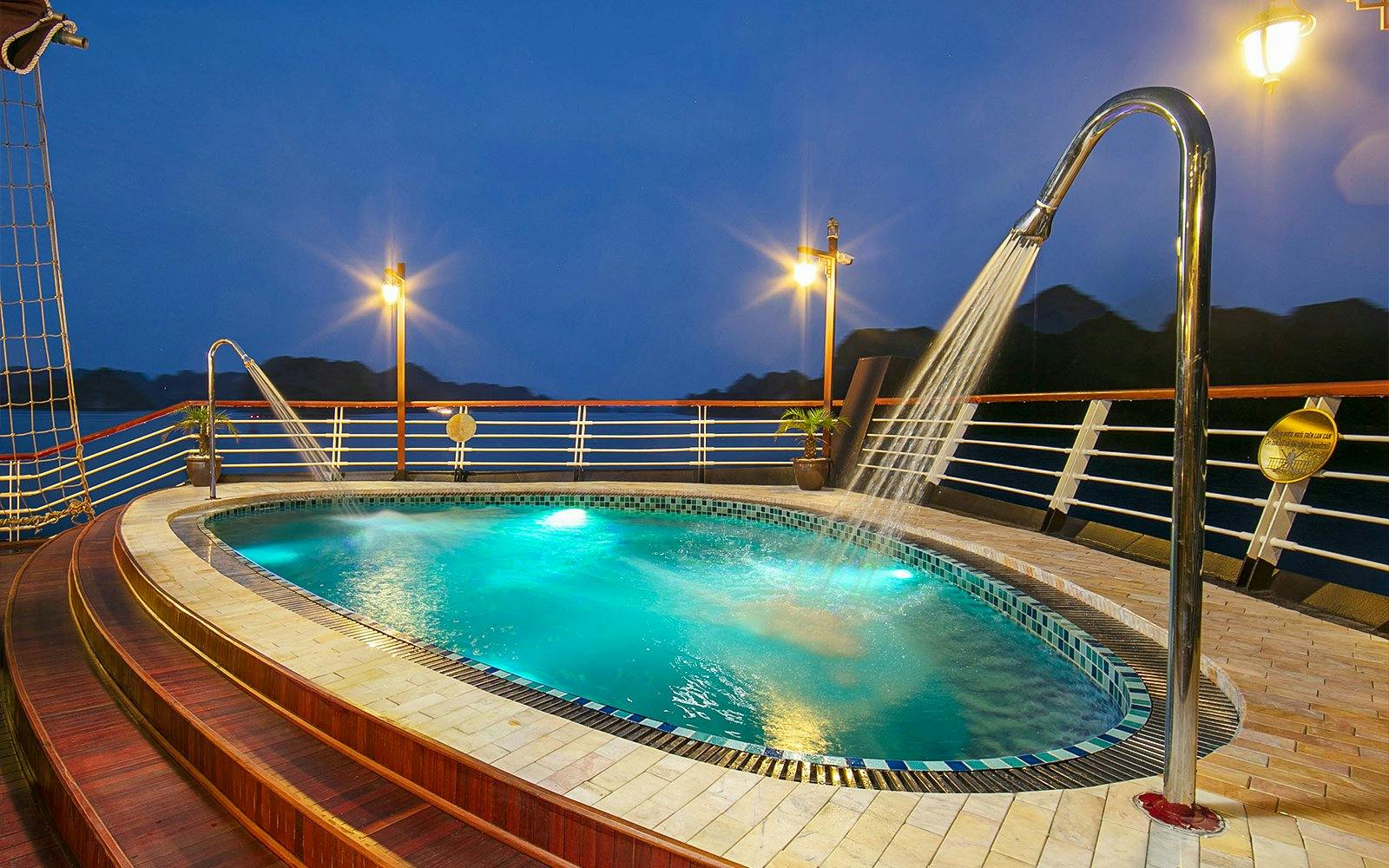 Pool on Amanda Luxury Cruise deck illuminated at night.