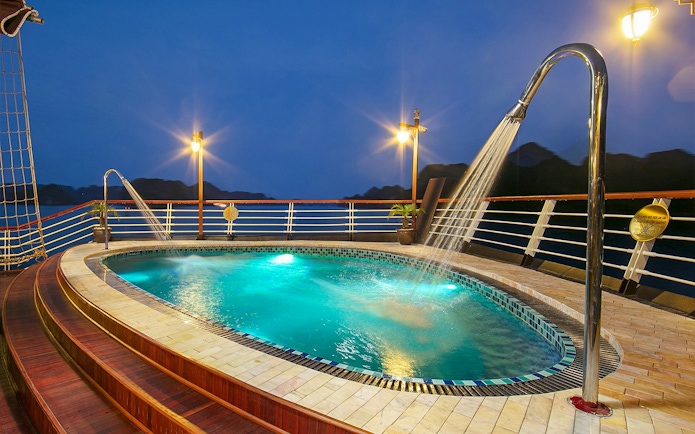 Pool on Amanda Luxury Cruise deck illuminated at night.