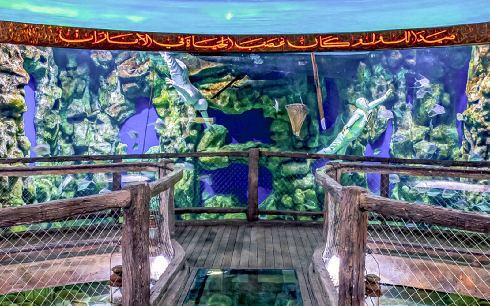 Aquarium tunnel with diver and fish in Dubai Mall, UAE.