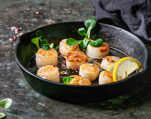 Seared scallops with lemon and greens in a pan, Madrid in January.