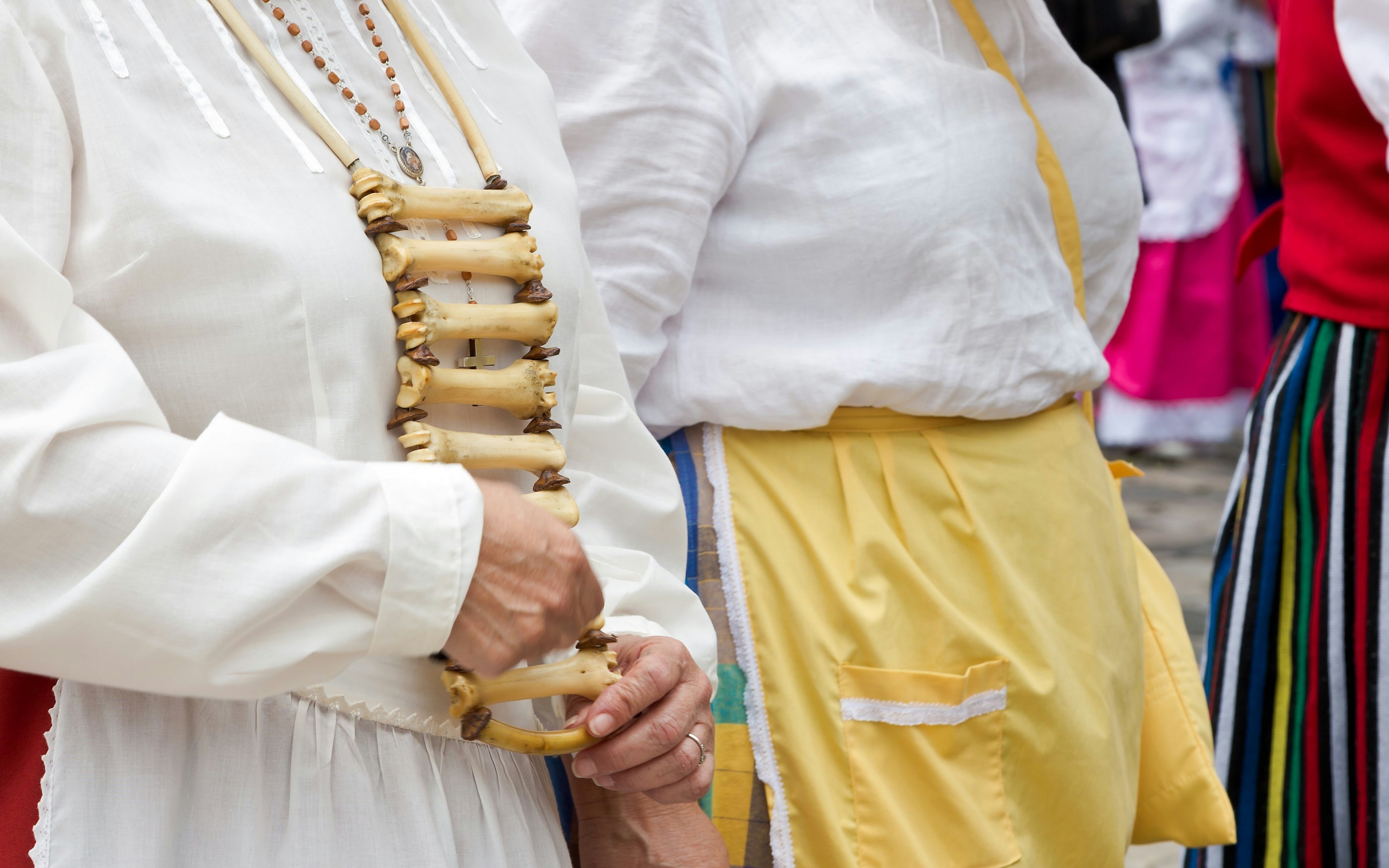Traditional attire with bone necklace at a pilgrimage parade in Spain.