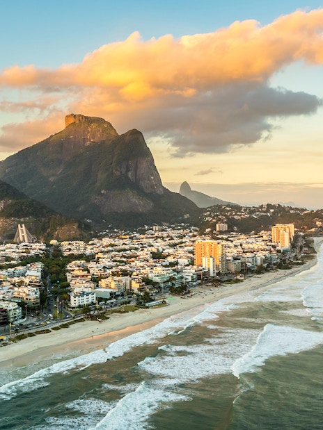 Aerial view of Rio de Janeiro coastline and mountains at sunset.