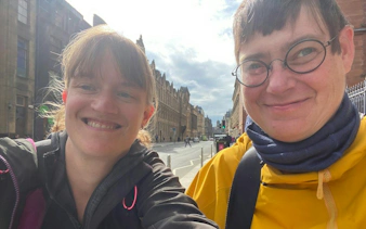 Two people smiling on a street in Glasgow's West End during a self-guided city exploration game.