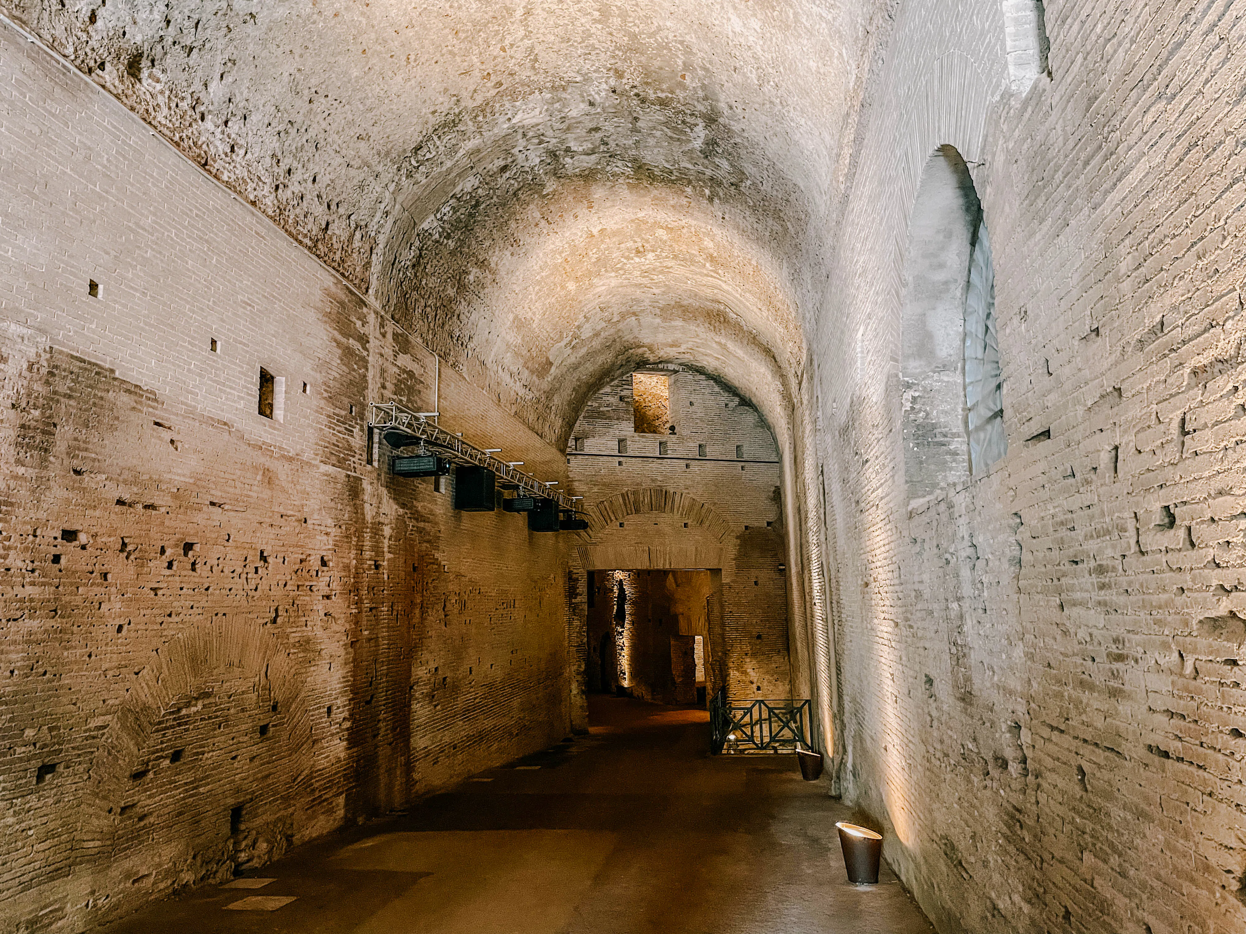 Ancient brick corridor inside Domus Aurea, Rome, showcasing arched ceilings and historic architecture.