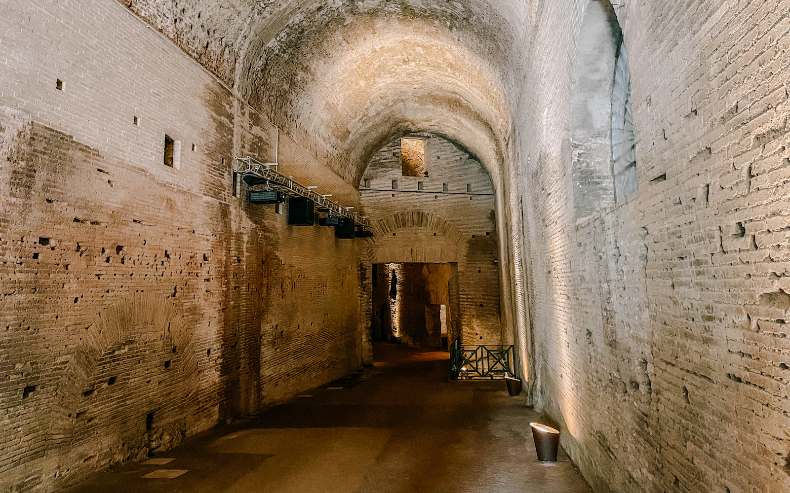 Ancient brick corridor inside Domus Aurea, Rome, showcasing arched ceilings and historic architecture.
