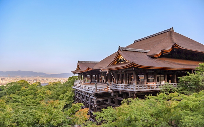 Kiyomizu Temple exterior with wooden terrace overlooking Kyoto cityscape.