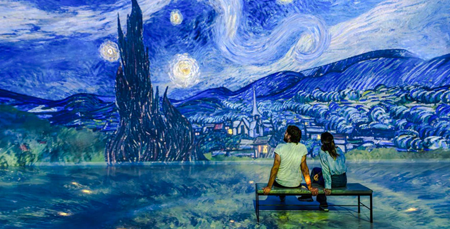 Guests viewing Van Gogh's 'Starry Night' at Frameless London exhibit.