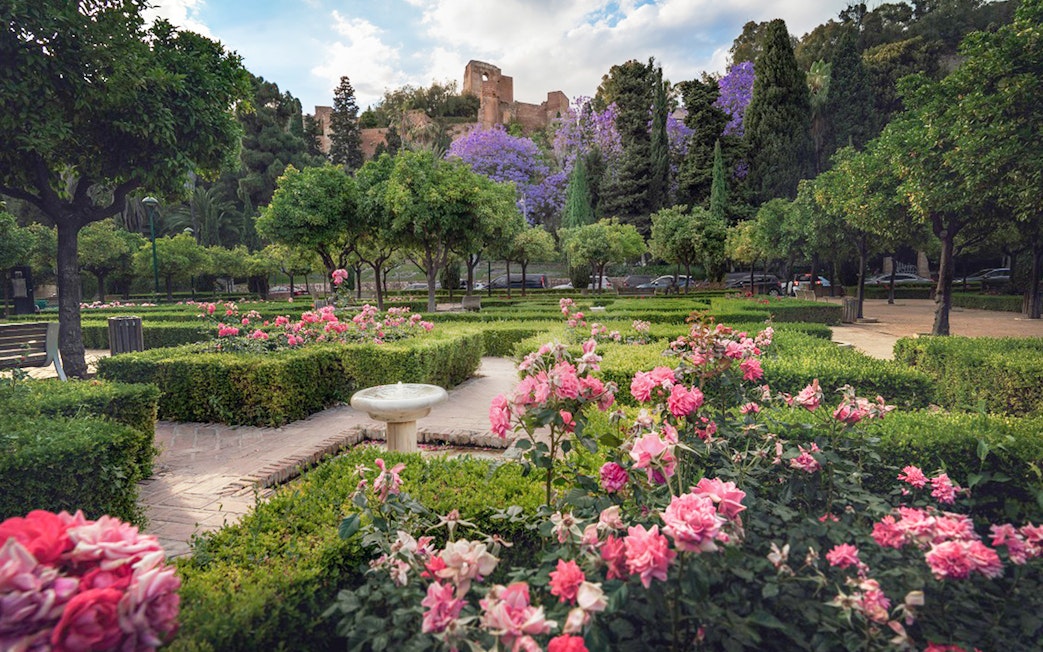 Roman Theater and Alcazaba Castle gardens with blooming flowers and lush greenery.