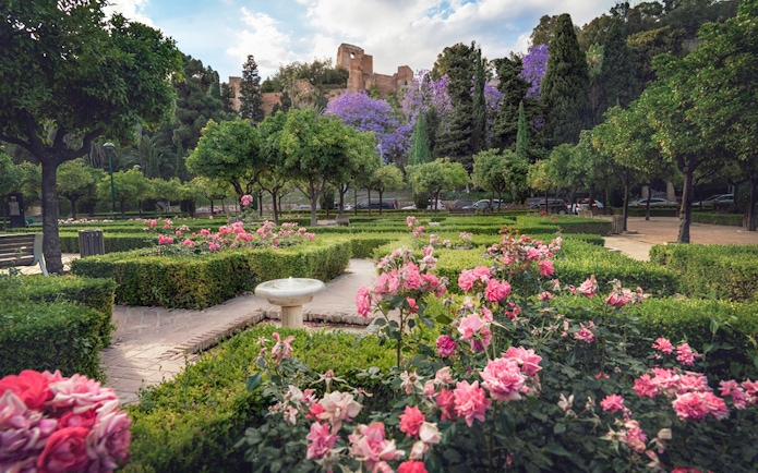 Roman Theater and Alcazaba Castle gardens with blooming flowers and lush greenery.