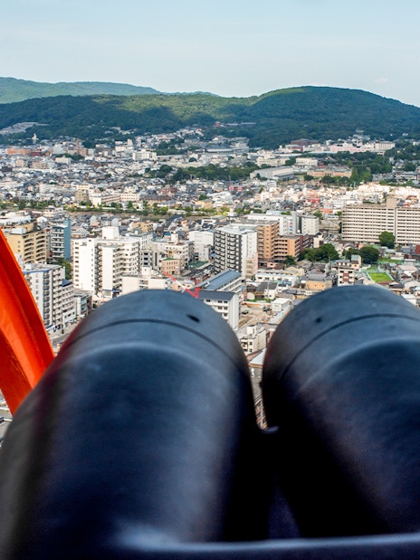 View of Kyoto cityscape from Kyoto Tower observation deck with binoculars.