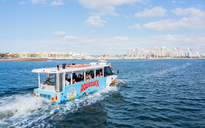 Aquaduck tour boat sailing near Sunshine Coast skyline.