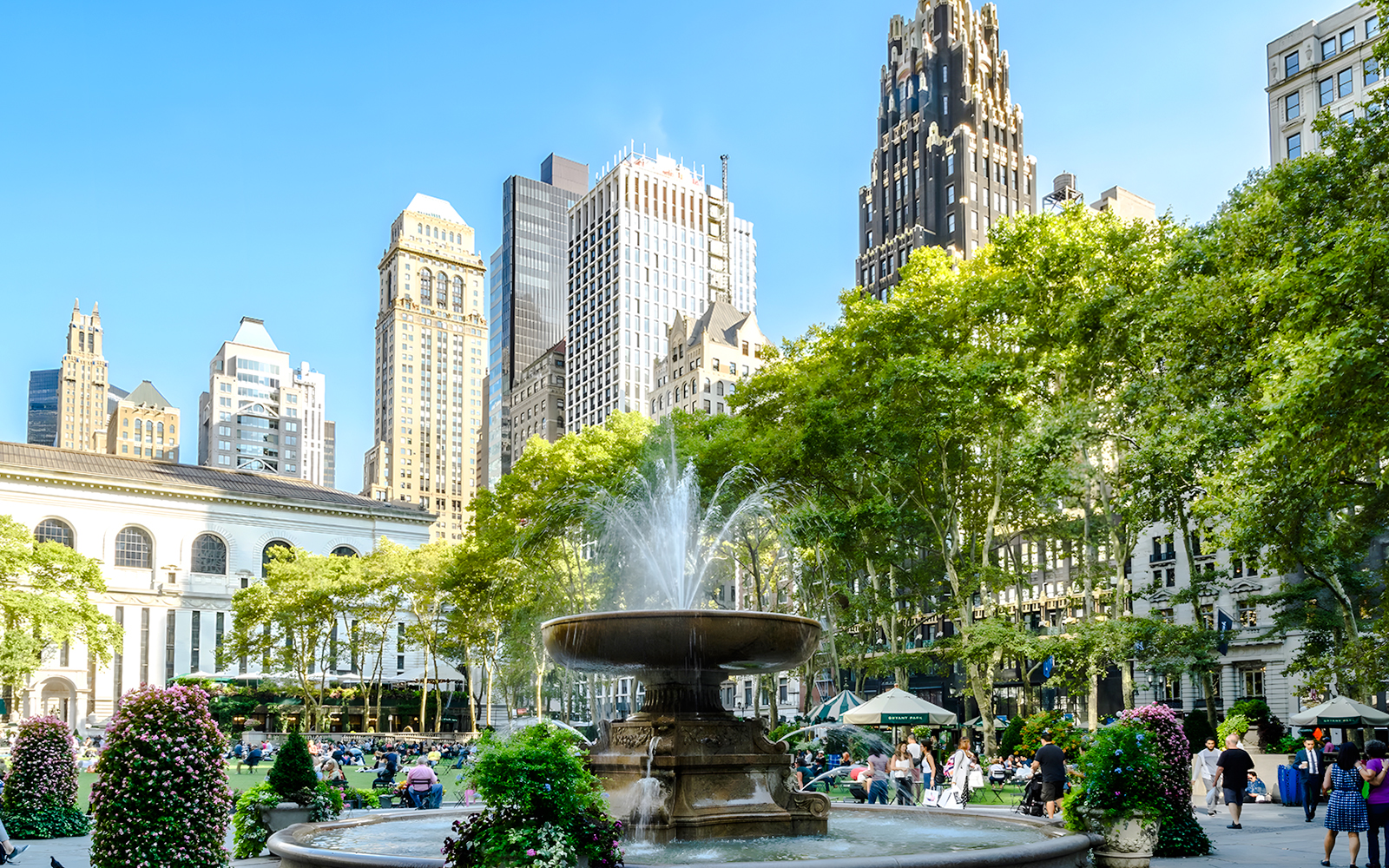 Bryant Park fountain with skyscrapers and trees in New York City.