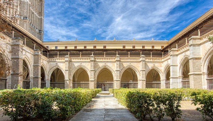Cloister of Toledo Cathedral with Gothic arches and garden, part of Madrid to Segovia, Ávila, and Toledo excursion.
