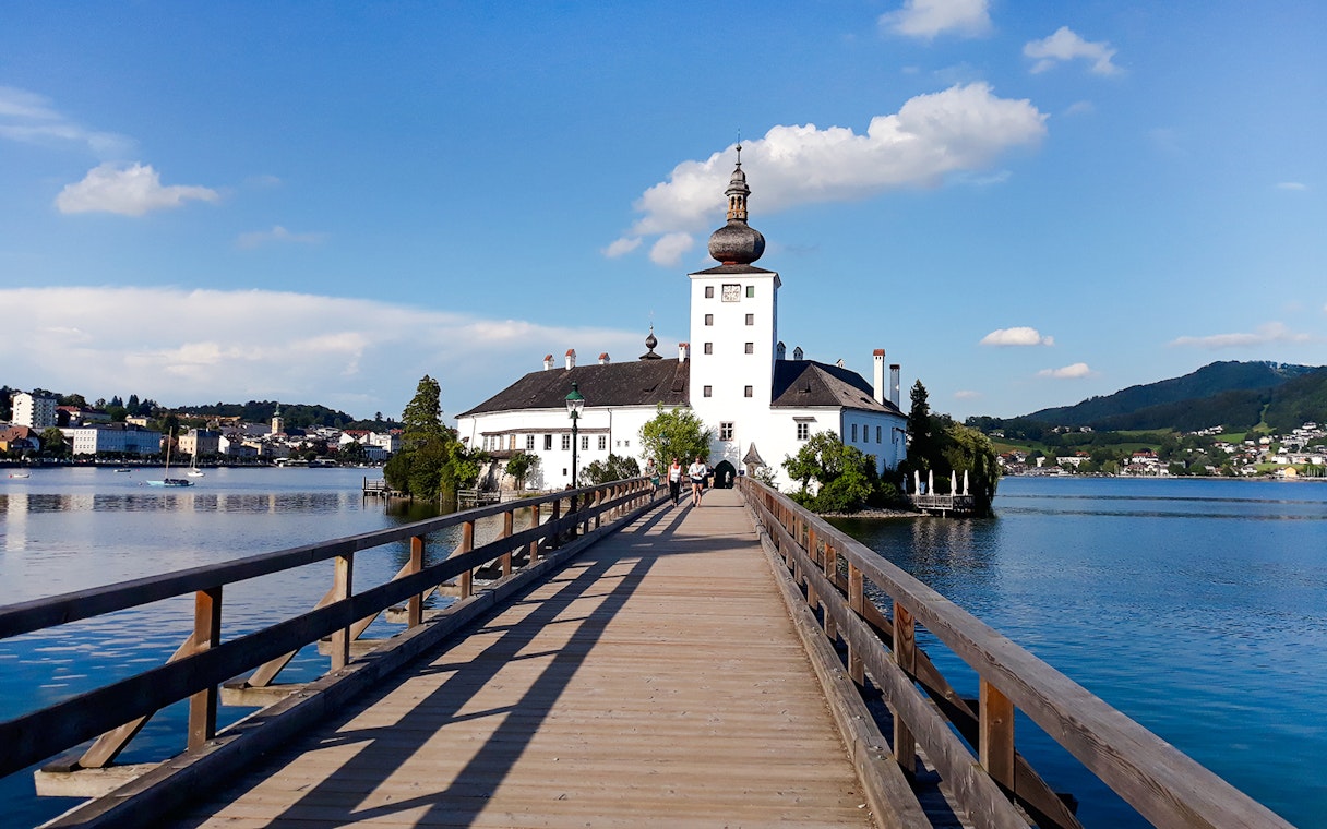 Wooden bridge leading to Schloss Ort palace on Lake Traunsee, Austria.