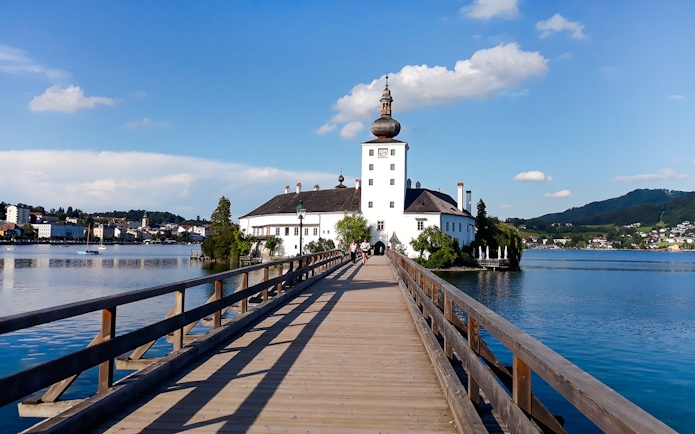 Wooden bridge leading to Schloss Ort palace on Lake Traunsee, Austria.