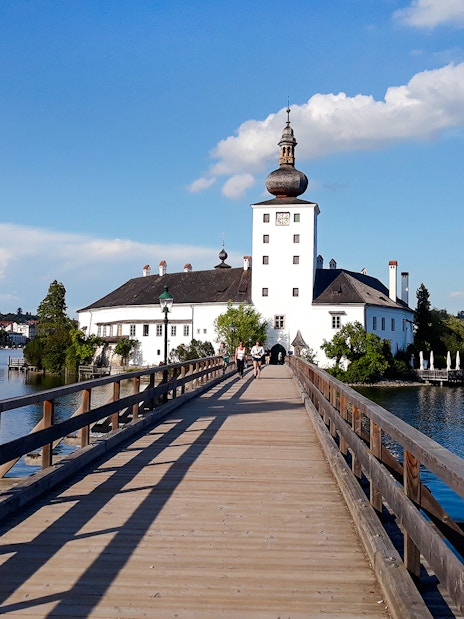 Wooden bridge leading to Schloss Ort palace on Lake Traunsee, Austria.