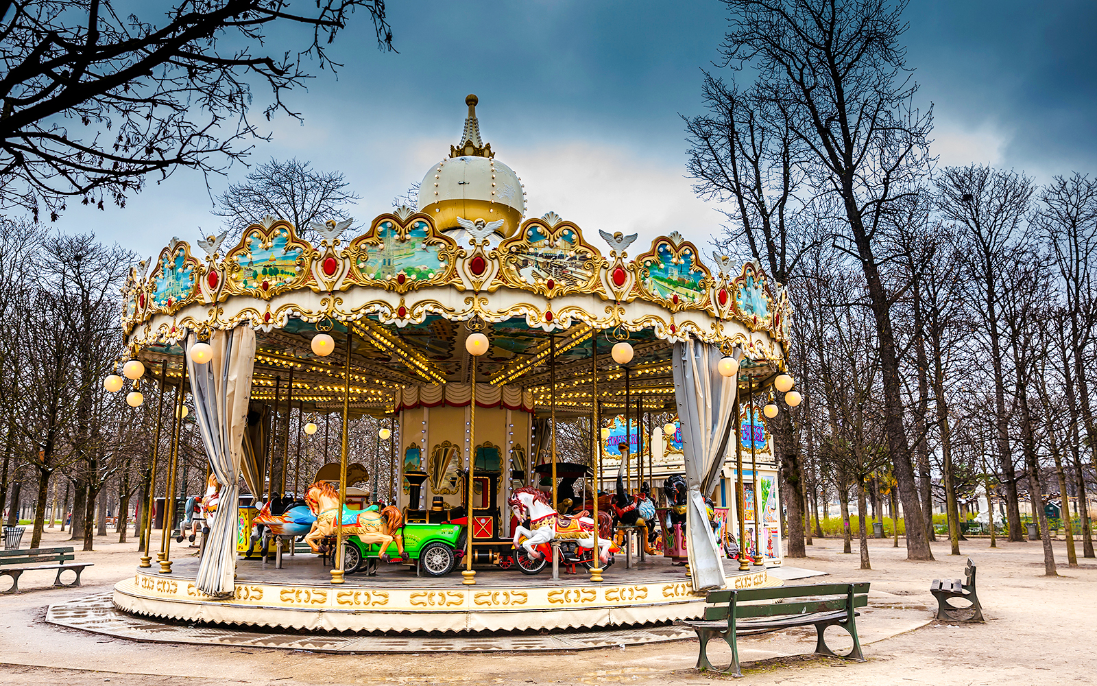 Carousel at Tuileries Garden in Paris surrounded by bare trees.