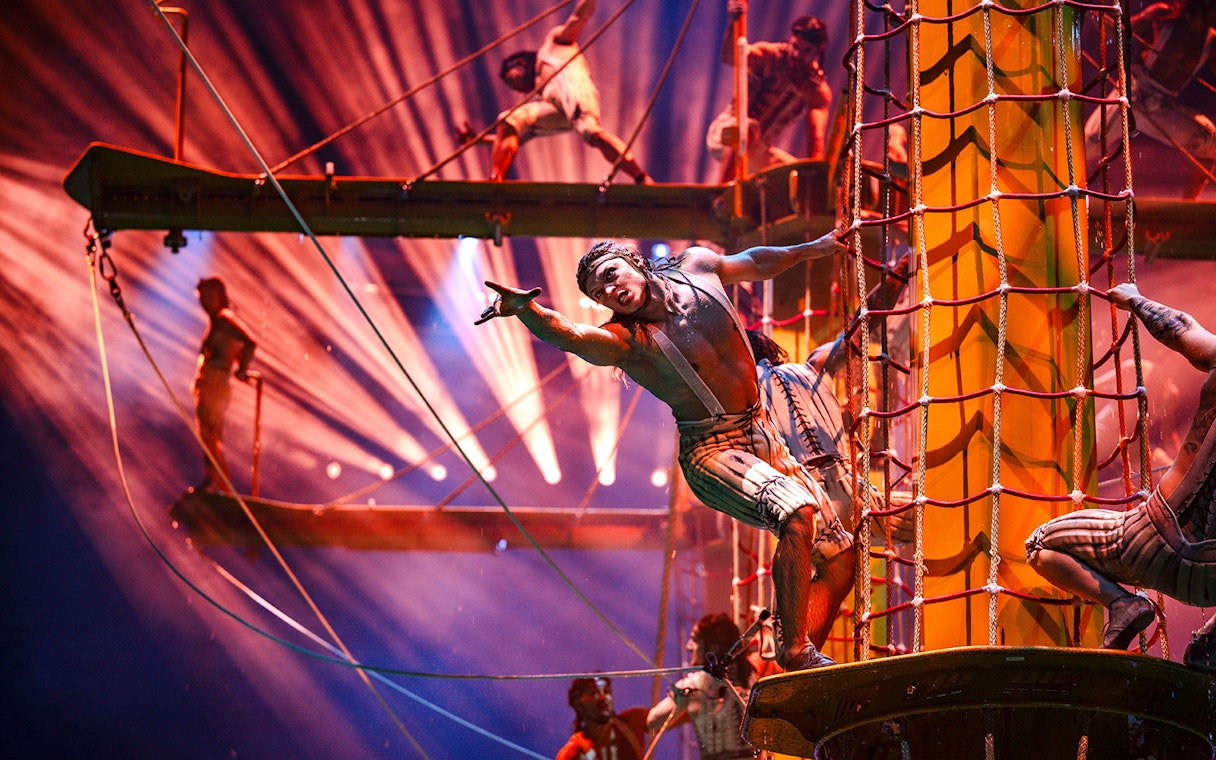 Acrobats performing on ropes and platforms during House of Dancing Water show.