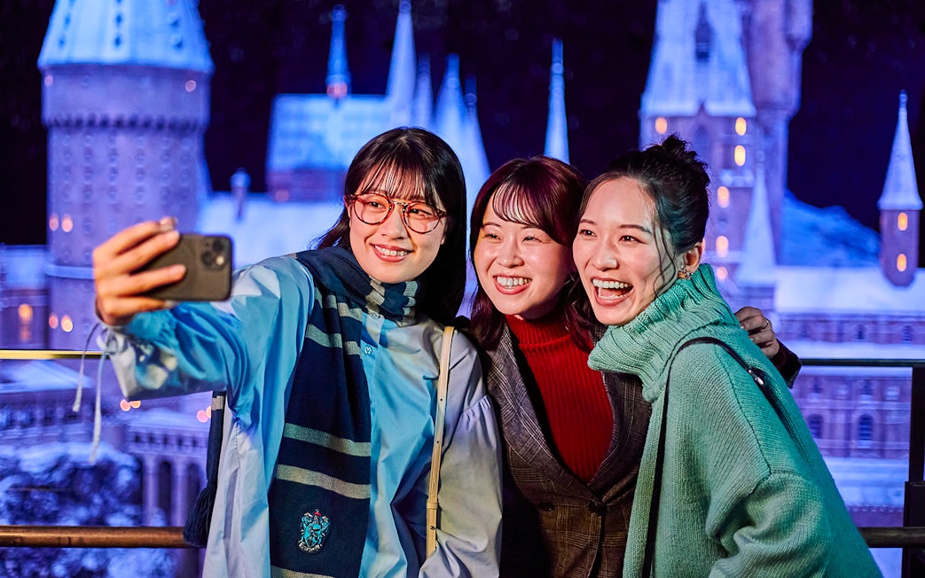 Visitors taking a selfie with the Hogwarts castle model at The Making of Harry Potter Studio Tour, Tokyo.