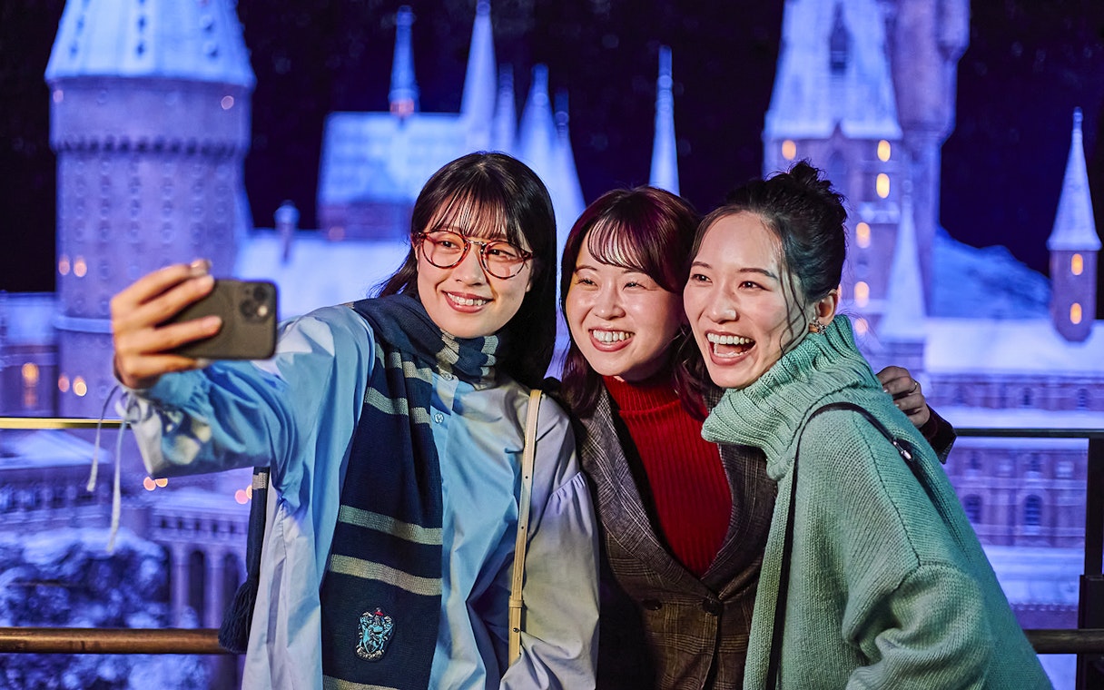 Visitors taking a selfie with the Hogwarts castle model at The Making of Harry Potter Studio Tour, Tokyo.