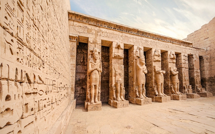 Temple of Medinet Habu with hieroglyphics and statues, Luxor, Egypt.