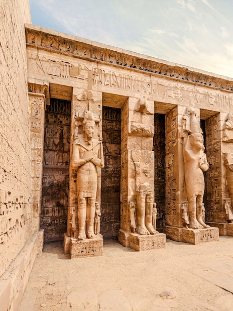 Temple of Medinet Habu with hieroglyphics and statues, Luxor, Egypt.