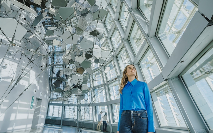 Person inside Glories Skyline Tower with geometric ceiling design.