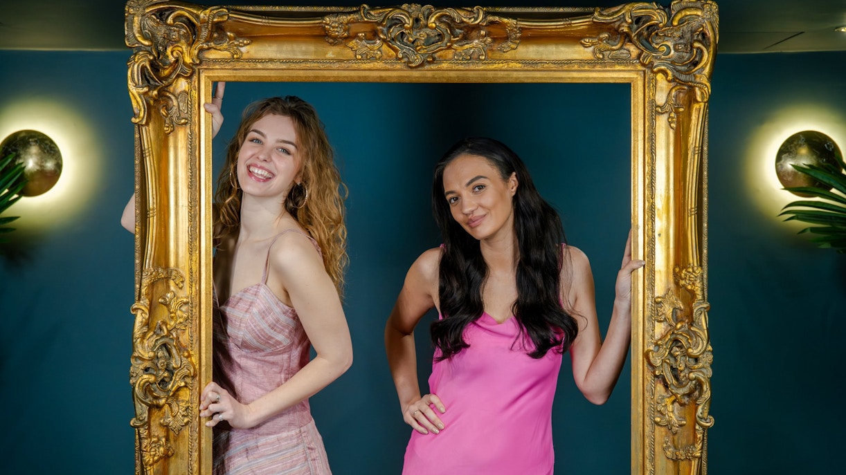 Guests posing with a golden frame at Madame Tussauds Champagne bar.