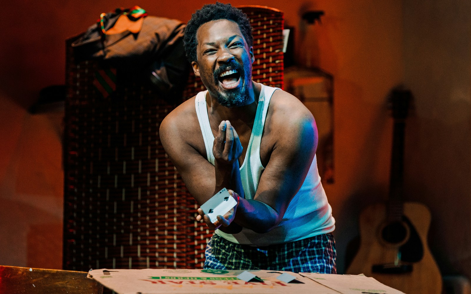 Man performing a card trick in a scene from Topdog/Underdog play.