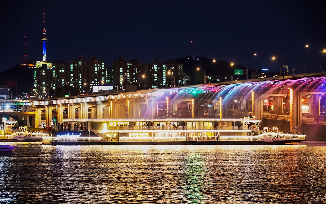 Han River cruise at night with Banpo Bridge Rainbow Fountain show in Seoul.
