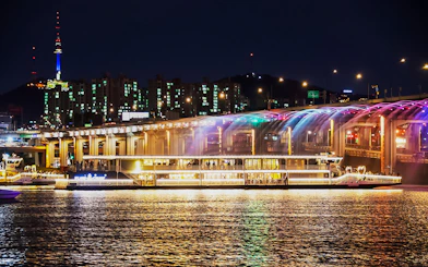 Han River cruise at night with Banpo Bridge Rainbow Fountain show in Seoul.