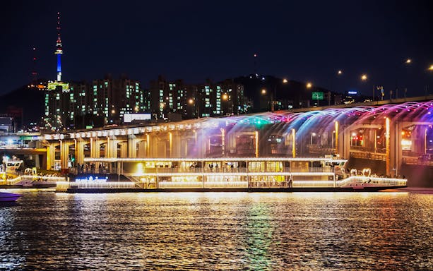 Han River cruise at night with Banpo Bridge Rainbow Fountain show in Seoul.